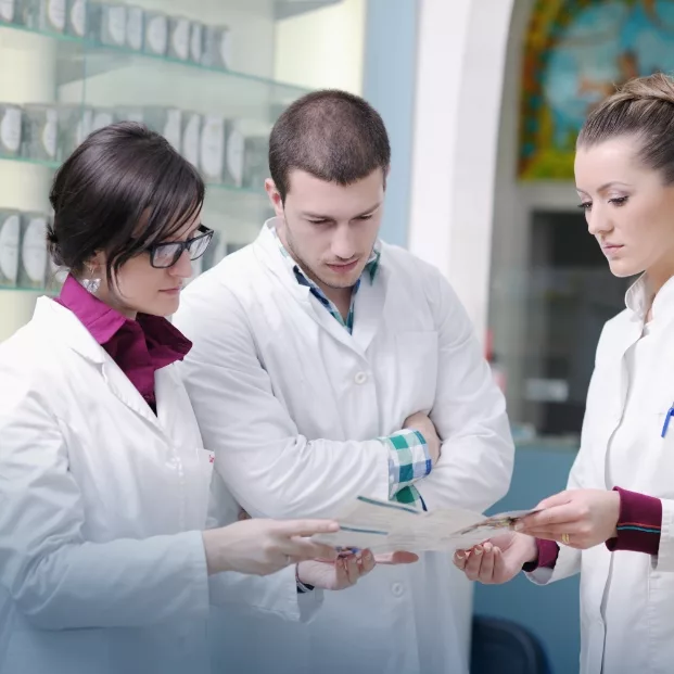 Drei osteuropäische Pharmazeuten diskutieren über ein Medikament.